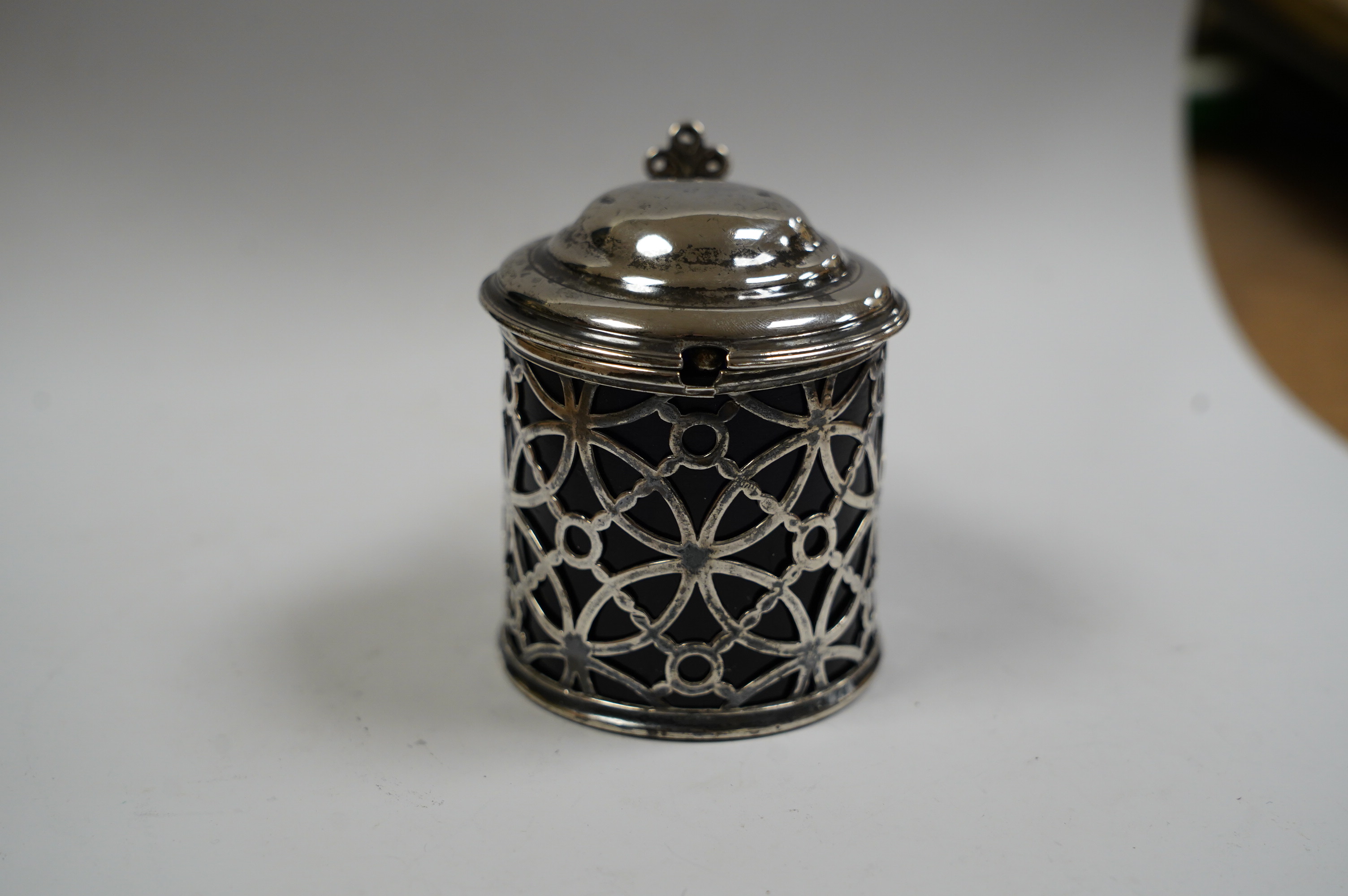 A George III pierced silver drum mustard pot, Aldridge & Green, London, 1767, height 70mm lid unmarked, with blue glass liner, later associated silver spoon. Condition - poor to fair